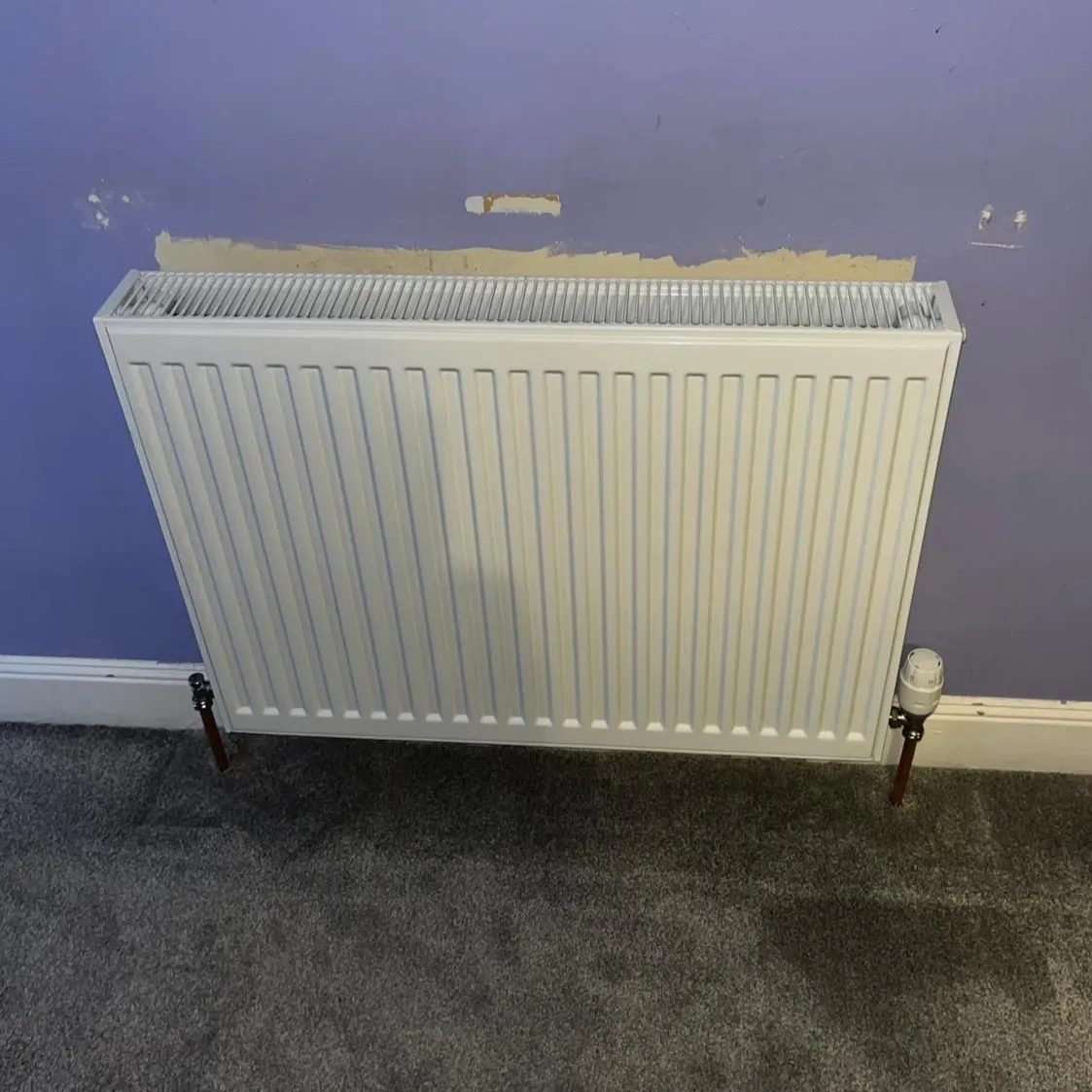 white steel compact panel radiator mounted on a wall